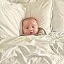 baby, blanket, pillow, bed, child, face, infant, cozy, white, soft, comfort, rest, indoors, sleepwear, cute, portrait, lying_down, skin, head, expression
