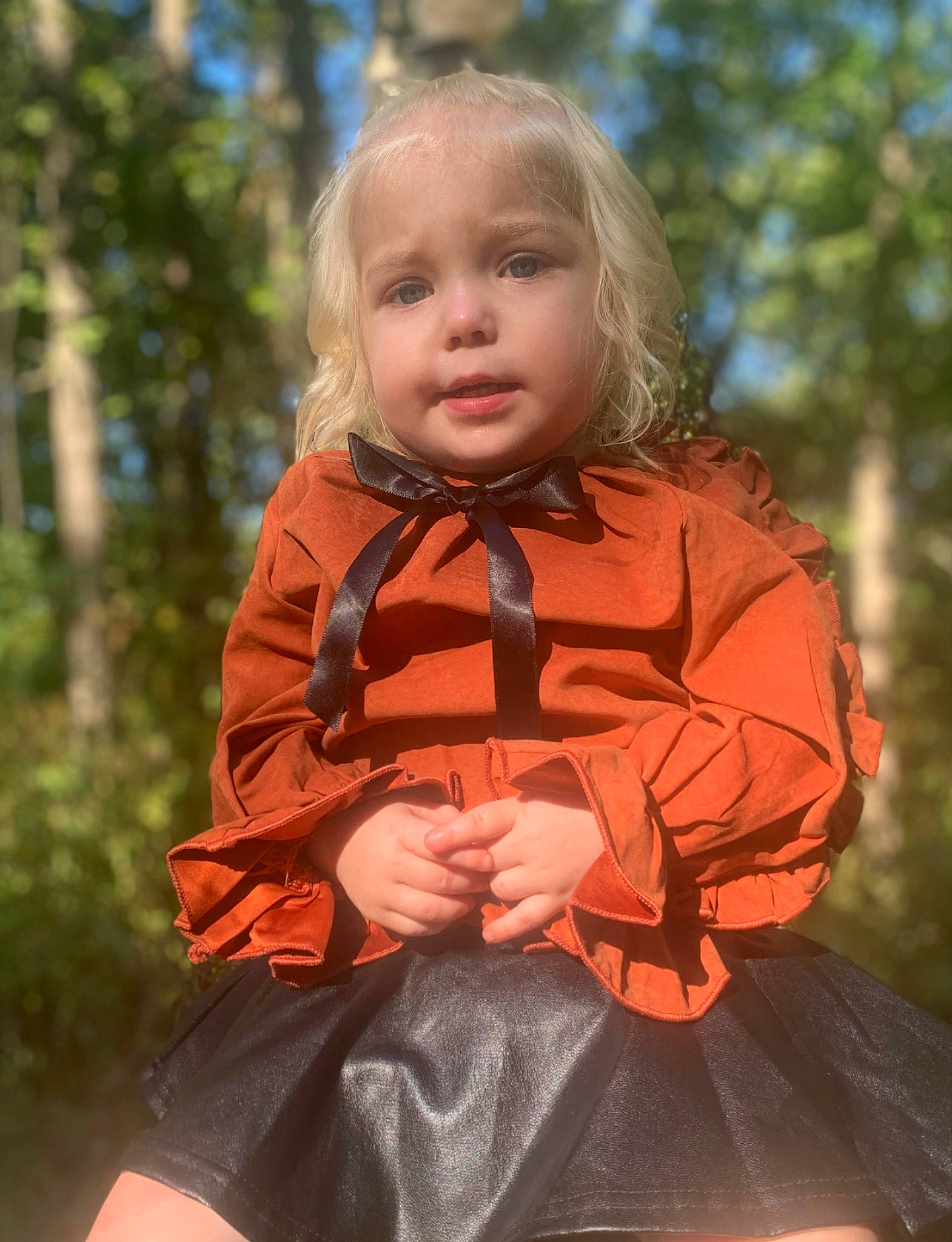 Adalyn is registered to the contest to win money with this photo: baby, baby_toddler_clothing, blond, child, eye, fun, grass, happy, iris, jacket, leaf, leisure, orange, people_in_nature, person, recreation, sitting, sleeve, toddler, tree