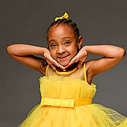 Milani is registered to the contest to win money with this photo: child, girl, yellow_dress, smiling, posing, happy, portrait, studio, fashion, tulle, bow, hair_accessory, cute, young, joyful, isolated, background, skin, face, arms