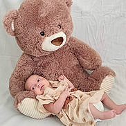 Jenna a rejoint le concours — aidez-le/la à gagner de superbes lots ! baby, teddy_bear, plush_toy, child, infant, soft_toy, cute, dress, fabric, lying_down, indoors, comfort, white_background, toy, cuddly, peaceful, small, smiling, relaxed, portrait