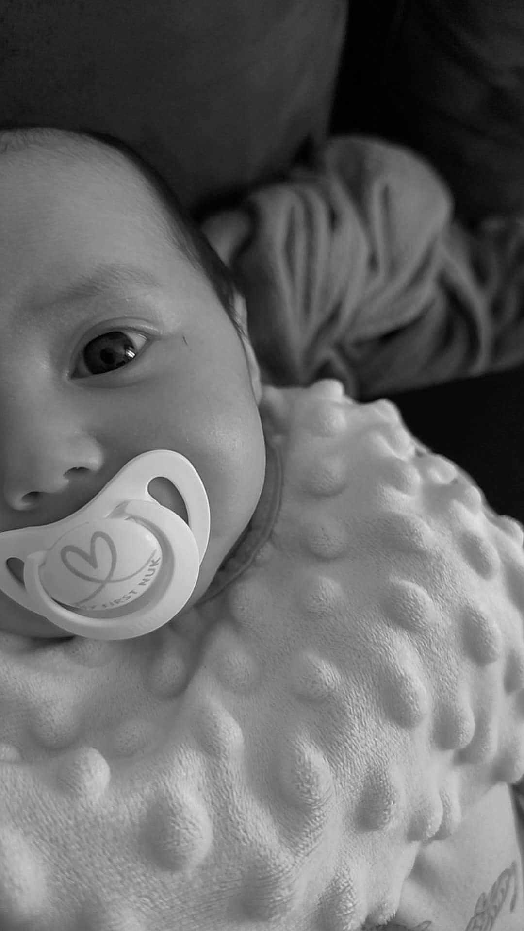Jenna a rejoint le concours — aidez-le/la à gagner de superbes lots ! baby, infant, pacifier, blanket, close_up, face, black_and_white, texture, cozy, comfort, child, cute, soft, portrait, newborn, expression, indoor, sleepwear, rest, young