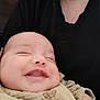 Hailey participe au concours pour gagner de l'argent avec cette photo : baby, smiling, closeup, blanket, infant, person, black_shirt, happy, cute, face, child, comfort, holding, skin, mouth, head, young, portrait, expression, joy