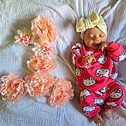 Gireh joined the competition — help win amazing prizes! baby, infant, sleeping, smiling, headband, bow, hello_kitty, pink_clothing, flowers, peach_flowers, blanket, soft_texture, cute, child, portrait, resting, indoors, cozy, happy, newborn