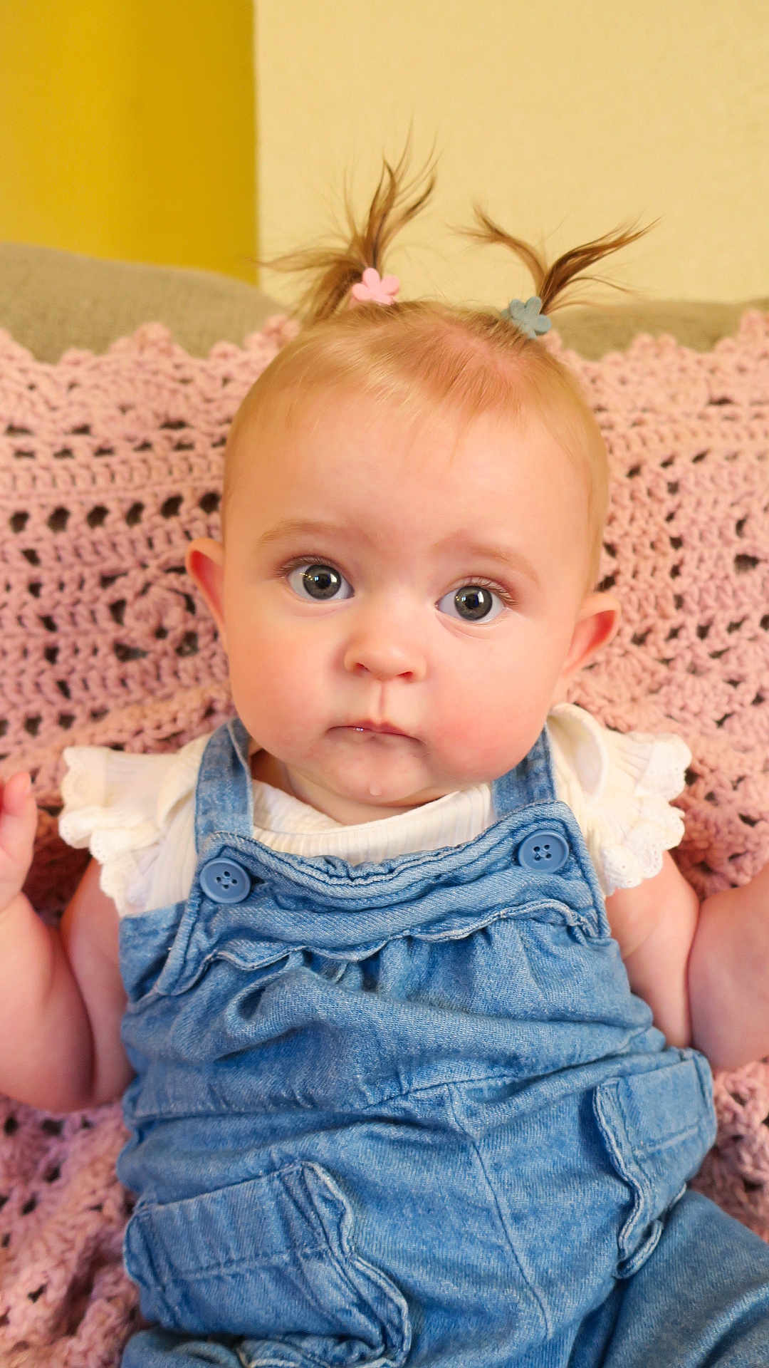 Josie joined the competition — help win amazing prizes! baby, child, pigtails, denim_overalls, white_shirt, crocheted_blanket, pink_blanket, curious_expression, wide_eyes, droplet, cute, indoor, portrait, infant, soft_lighting, small_hands, seated, face, head, clothing