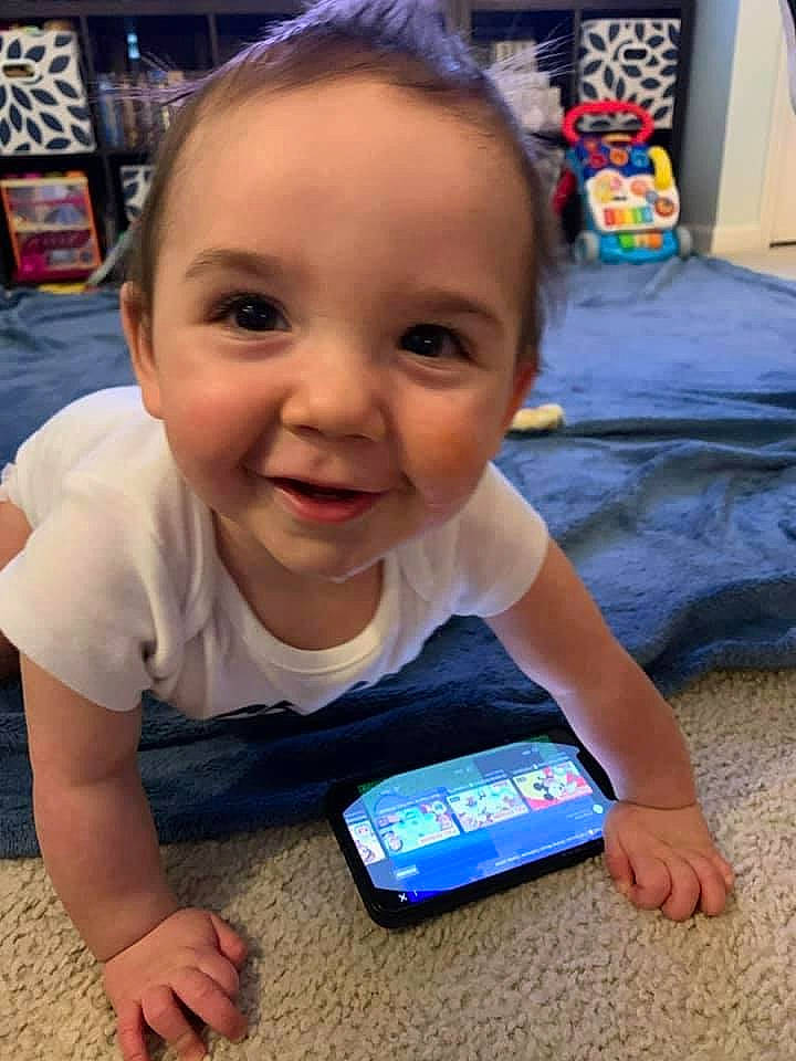 Lincoln joined the competition — help win amazing prizes! baby, baby_toddler_clothing, blue, blurred, cheek, child, communication_device, electric_blue, electronic_device, finger, flooring, fun, happy, head, joy, nose, person, portable_communications_device, sitting, skin
