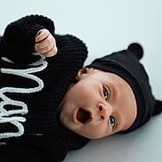 Manel a rejoint le concours — aidez-le/la à gagner de superbes lots ! baby, infant, blue_eyes, black_hat, black_sweater, knitwear, cute, lying_down, expression, mouth_open, soft_surface, portrait, child, newborn, hat_with_ears, closeup, indoor, warm_clothing, face, person