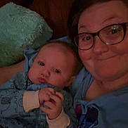 Dallas is registered to the contest to win money with this photo: baby, adult, glasses, pajamas, couch, pillow, indoor, portrait, smile, face, person, cozy, family, together, child, hand, clothing, home, relaxing, closeup