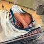 newborn, baby, blanket, hospital, bassinet, sleeping, infant, wrapped, arm, face, peaceful, cozy, hospital_bed, newborn_baby, skin, hair, indoor, closeup, person, quiet