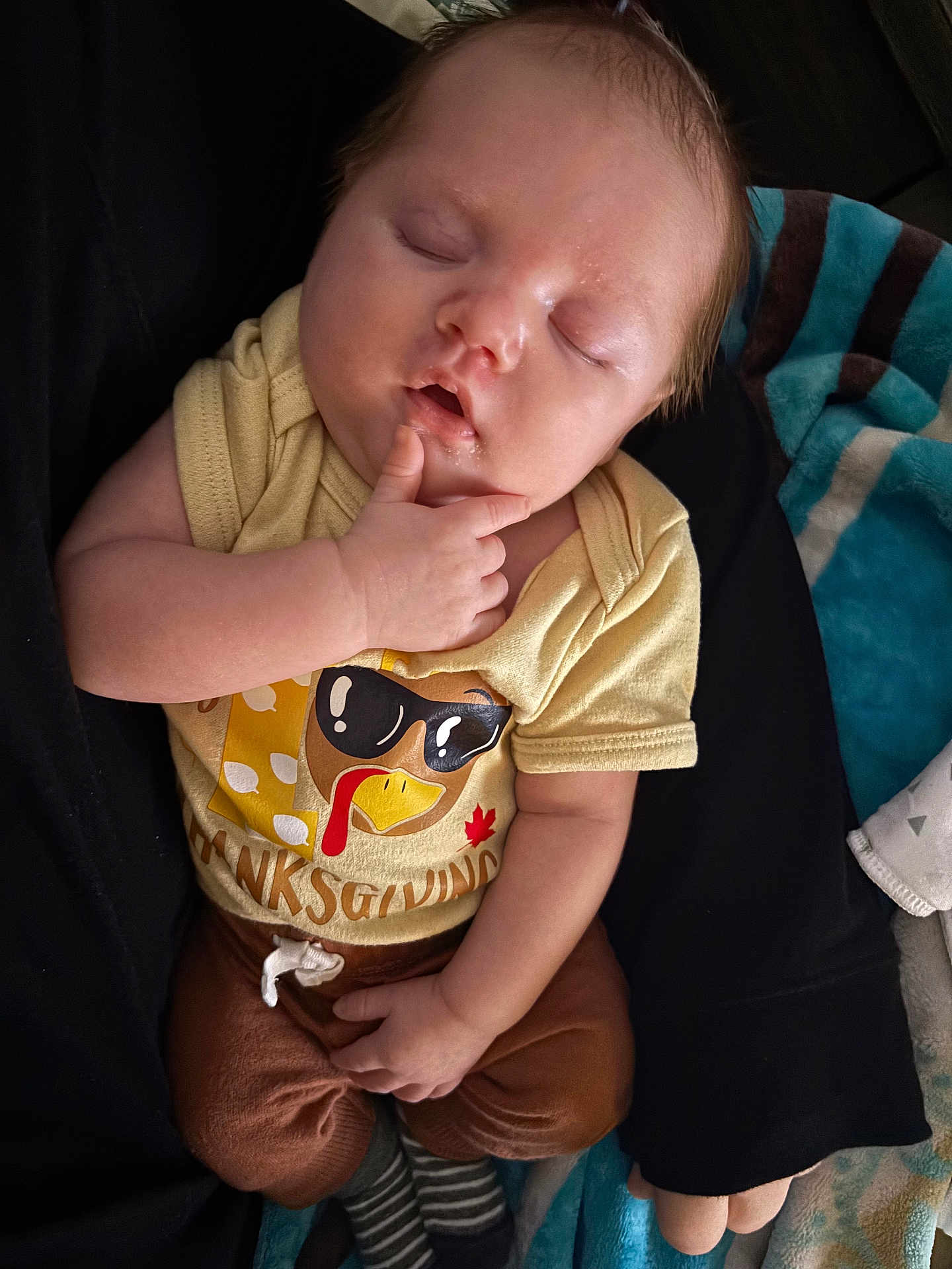Dallas joined the competition — help win amazing prizes! baby, sleeping, infant, thanksgiving, clothing, hand, face, cute, cozy, blanket, striped, brown_pants, yellow_shirt, person, portrait, indoors, soft_lighting, relaxed, peaceful, child