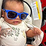 baby, child, sunglasses, blue, car_seat, onesie, animal_print, cool, infant, cute, portrait, clothing, seatbelt, smile, person, face, head, indoor, fashion, accessory