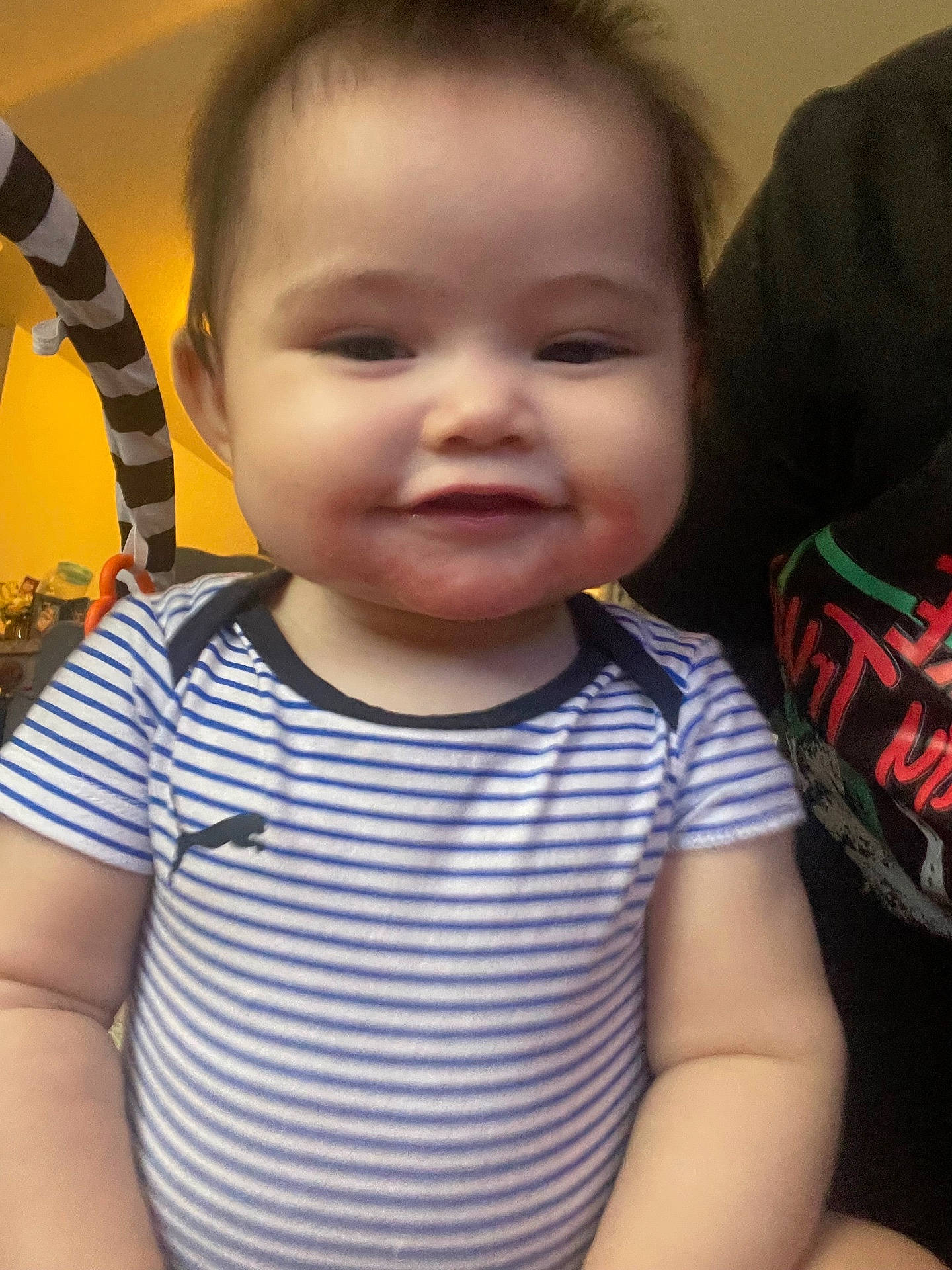 Sammy joined the competition — help win amazing prizes! baby, black_and_white, cheeks, child, close_up, clothing, cute, face, happy, human, indoor, infant, person, portrait, seated, short_hair, smile, striped_shirt, toy, yellow_background
