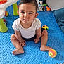 baby, child, indoor, playmat, toy, colorful, cushion, floor, sitting, cute, curious, white_clothing, short_hair, looking_at_camera, play_area, tiled_floor, young_child, smiling, person, home
