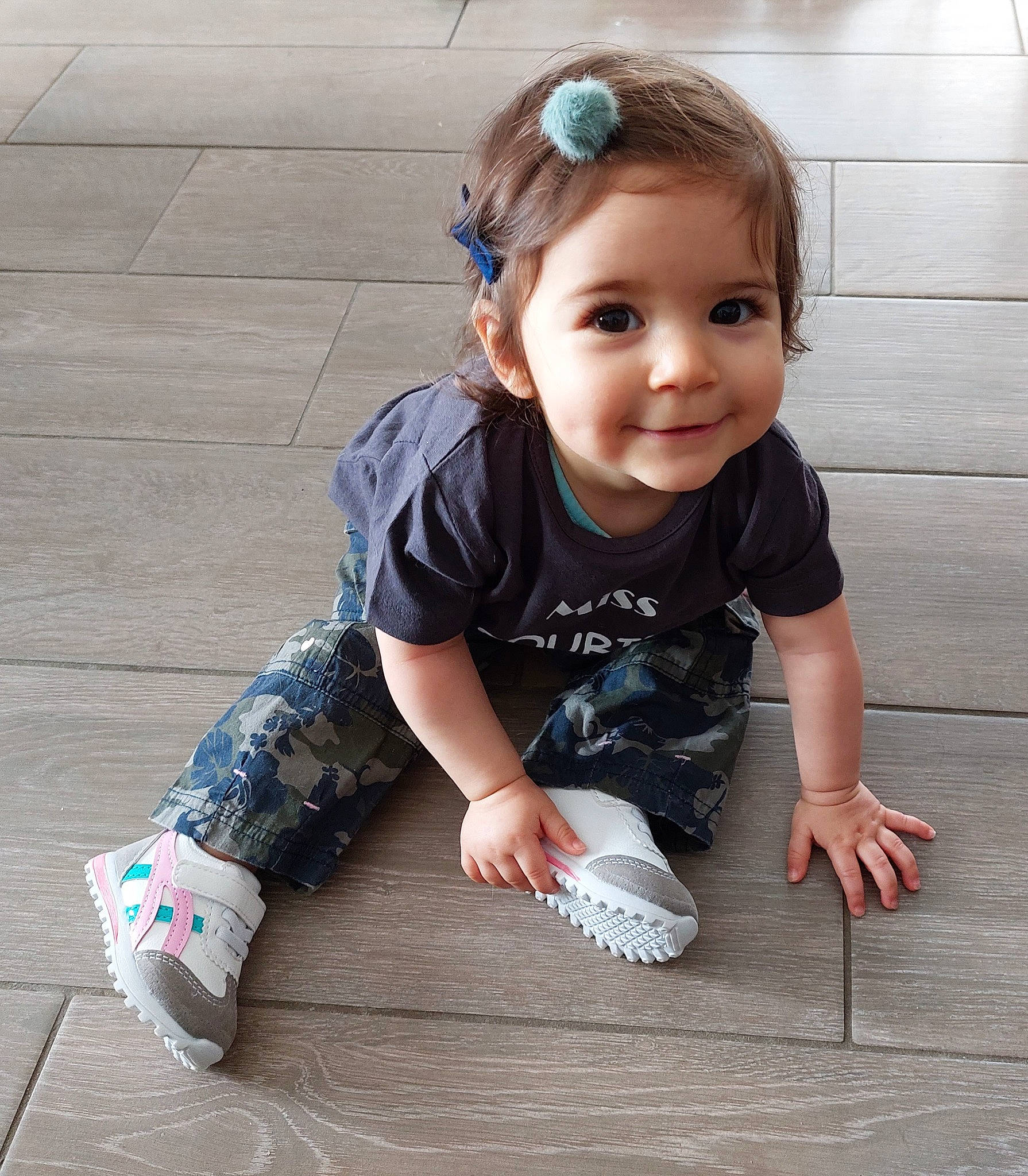 Emy a rejoint le concours — aidez-le/la à gagner de superbes lots ! baby, baby_toddler_clothing, cheek, child, floor, flooring, hairstyle, happy, hardwood, head, human_leg, joint, joy, pattern, person, sitting, skin, sleeve, smile, t_shirt