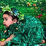 Naisha is registered to the contest to win money with this photo: baby, child, green_dress, flower_crown, butterfly, crawling, curious, floral, background, mushrooms, colorful, nature_theme, sock, bracelet, portrait, cute, whimsical, indoor, costume, playful