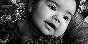 Naisha is registered to the contest to win money with this photo: baby, child, portrait, black_and_white, flower_crown, dress, sparkles, cute, face, earrings, soft_lighting, closeup, infant, adorable, smile, decorative, fabric, young_child, expression, headshot