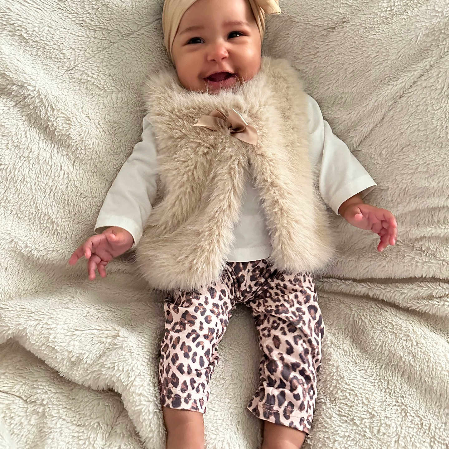 Lavaeah joined the competition — help win amazing prizes! baby, barefoot, blanket, bow, child, clothing, cute, face, fur, happy, headband, indoors, infant, leopard_print, lying_down, pants, portrait, smiling, soft_texture, vest