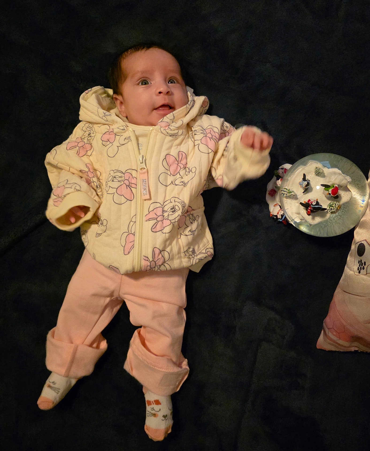 Mariah Recendez is registered to the contest to win money with this photo: baby, infant, child, clothing, jacket, pants, socks, face, person, lying_down, blanket, toy, snow_globe, indoor, cute, expression, curious, pink, yellow, decor