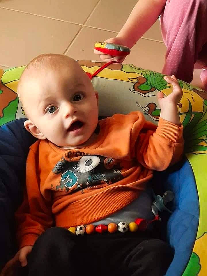 Orlane Dubrulle participe au concours pour gagner de l'argent avec cette photo : arm, baby, baby_products, baby_toddler_clothing, baby_toys, chair, cheek, child, comfort, event, fun, happy, lap, mouth, nail, orange, person, room, sitting, surprise