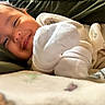 Priyah joined the competition — help win amazing prizes! newborn, baby, infant, child, face, smiling, sleepy, portrait, close_up, knitwear, white_clothing, blanket, bed, cozy, indoors, lying_down, soft_lighting, warm_tones, head, photography