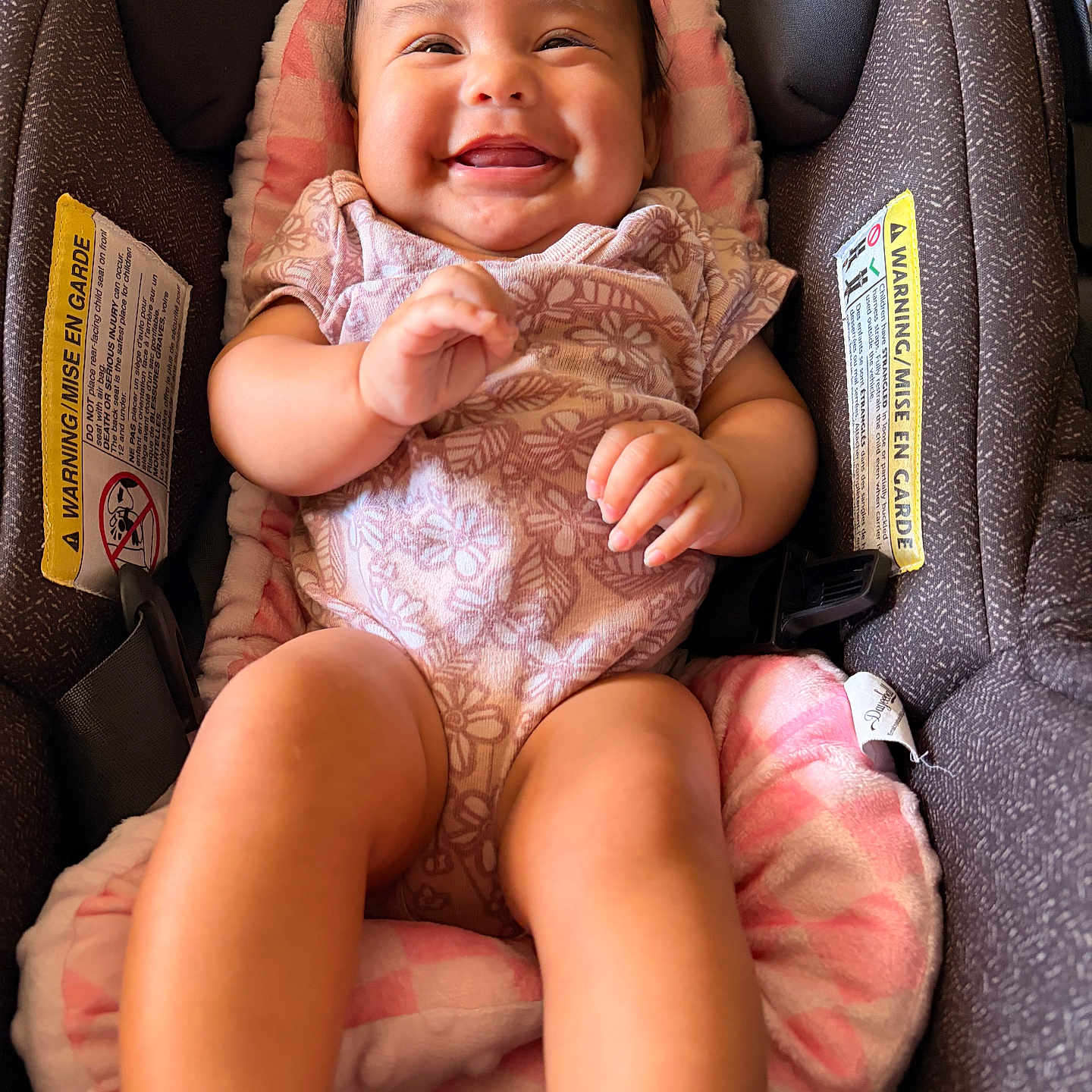 Priyah is registered to the contest to win money with this photo: baby, infant, child, smiling, happy, portrait, car_seat, safety_harness, pink_outfit, blanket, seated, indoor, close_up, face, eyes, hands, legs, floral_pattern, vehicle_interior,  안전
