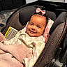 Priyah is registered to the contest to win money with this photo: baby, smile, car_seat, blanket, pajamas, pink_bow, infant, face, child, cute, indoors, clothing, happy, person, soft_texture, cozy, headwear, portrait, newborn, resting