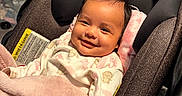 Priyah joined the competition — help win amazing prizes! baby, blanket, car_seat, child, clothing, comfort, cute, face, happy, head, indoors, infant, pajamas, person, pink_bow, portrait, seat, smile, soft, warm