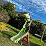 Tylio participe au concours pour gagner de l'argent avec cette photo : child, slide, playground, grass, outdoor, sky, clouds, swing, yellow_chair, tree, bush, house, daylight, toy, person, summer, backyard, fun, plastic, recreation