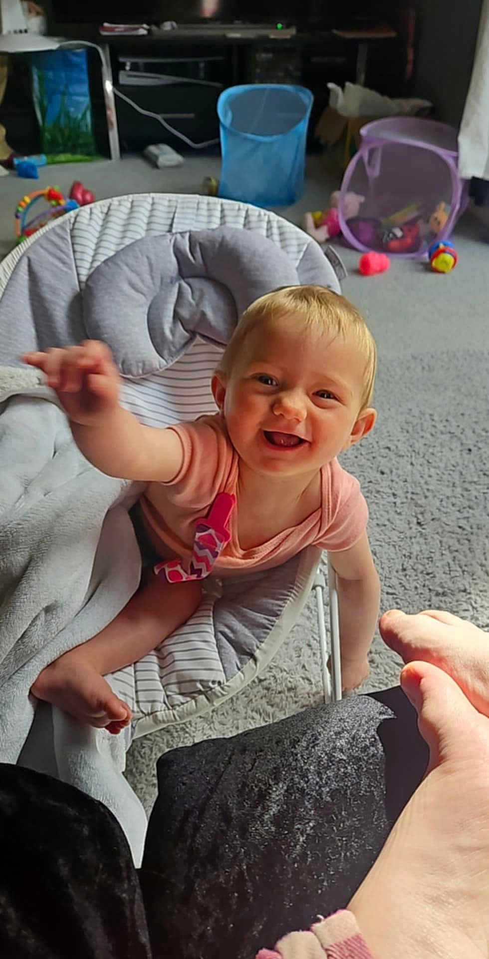 Alisha is registered to the contest to win money with this photo: baby, blanket, carpet, child, colorful, comfortable, cute, expression, foot, furniture, happy, home, indoor, infant, person, playroom, reaching, seat, smiling, toy