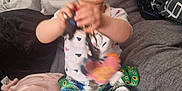 Alisha joined the competition — help win amazing prizes! baby, blanket, child, clothing, colorful, cushion, cute, floral_wallpaper, happy, home, indoor, infant, keys, patterned_pants, person, playful, sitting, smiling, toy, young_child