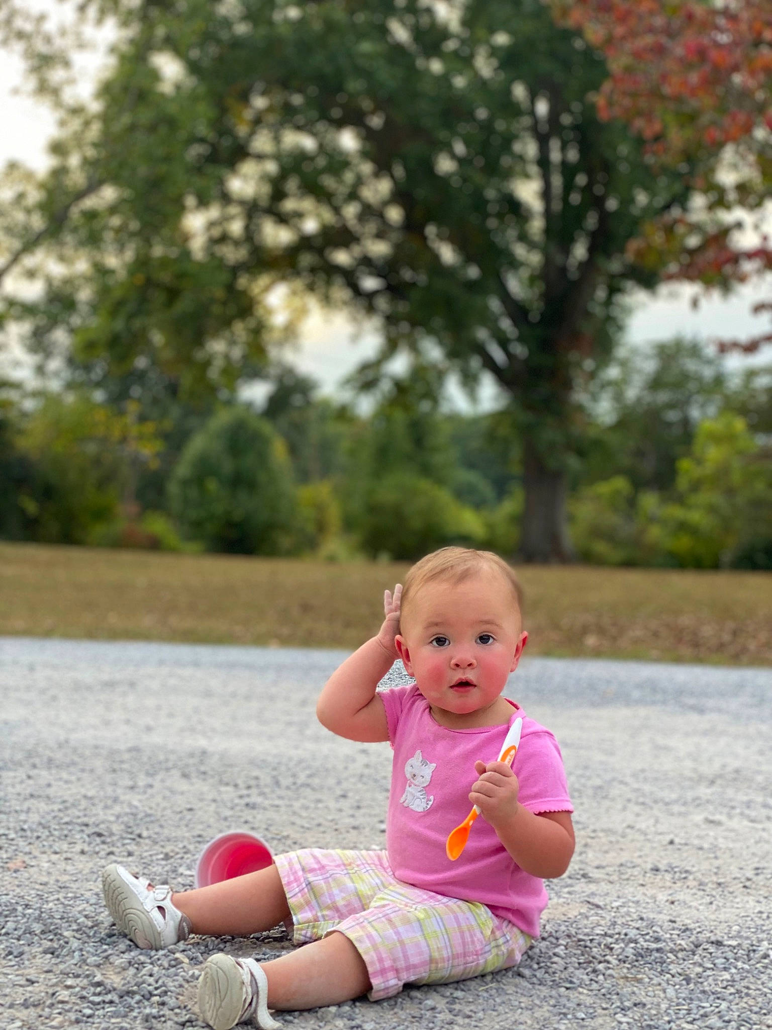 Sophia is registered to the contest to win money with this photo: asphalt, baby, baby_toddler_clothing, child, fun, grass, happy, human_leg, leaf, leisure, people_in_nature, person, pink, plant, recreation, shoe, sitting, sneakers, spring, surprise