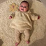 applique, baby, babylaughing, blanket, clothing, face, happy, head, homedecor, newborn, pants, pattern, person, photography, portrait, sitting, sleeve, smile, standing