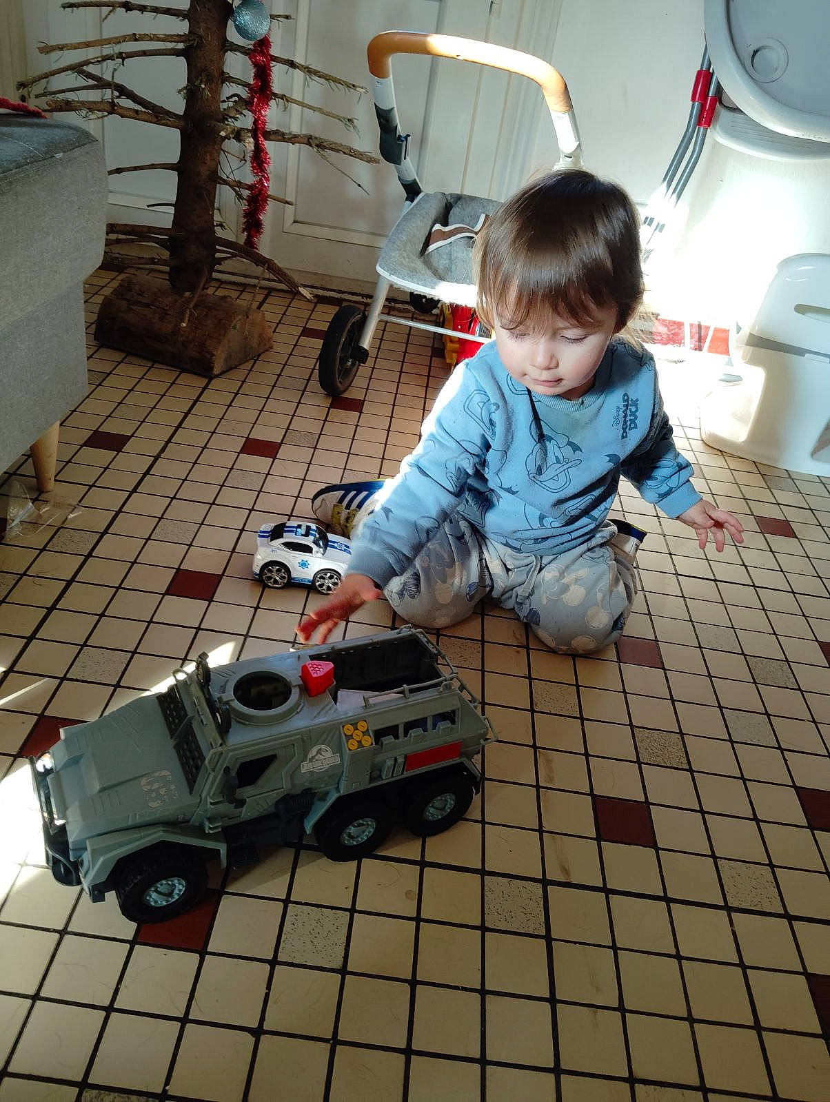 Zayan participe au concours pour gagner de l'argent avec cette photo : automotive_design, baby_toddler_clothing, child, engineering, floor, flooring, fun, hardwood, machine, motor_vehicle, person, play, sitting, space, tire, toddler, toy, toy_vehicle, vehicle, wheel