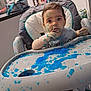 Léo participe au concours pour gagner de l'argent avec cette photo : baby, high_chair, blue_jelly, messy, food, kitchen, child, face, hands, tray, expression, indoor, curious, sitting, clothing, hair, footwear, table, background, household_items