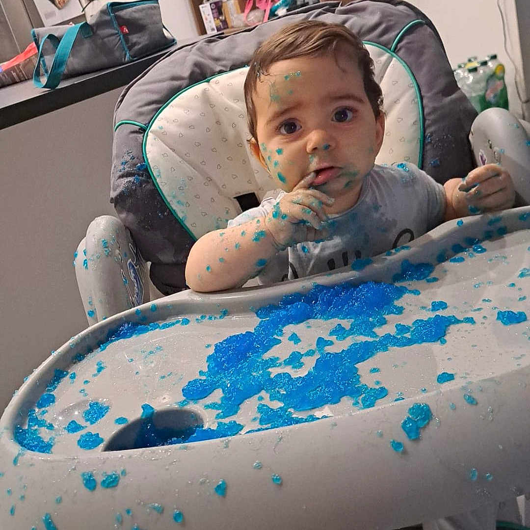Léo participe au concours pour gagner de l'argent avec cette photo : baby, background, blue_jelly, child, clothing, curious, expression, face, food, footwear, hair, hands, high_chair, household_items, indoor, kitchen, messy, sitting, table, tray