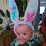 baby, bunny_ears, indoor, person, cute, child, animal_costume, headwear, plant, furniture, portrait, infant, holding, face, costume, home, decor, hand, clothing, floor