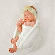 Roselie is registered to the contest to win money with this photo: newborn, baby, infant, sleeping, wrapped, blanket, headband, flower, white, soft, peaceful, cute, skin, feet, hands, portrait, indoors, closeup, resting, cozy