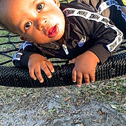 Kysin joined the competition — help win amazing prizes! child, toddler, boy, outdoor, playground, swing, rope_swing, nike, clothing, black_jacket, face, hands, sunlight, grass, dirt, fence, car, residential, curious, expression