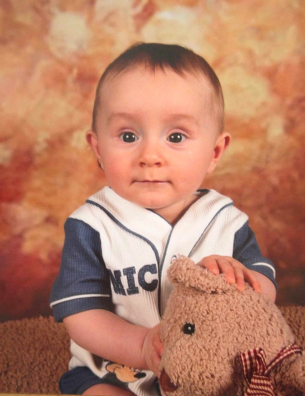 Zayden is registered to the contest to win money with this photo: baby, child, teddy_bear, plush_toy, portrait, cute, smiling, indoor, studio, clothing, short_hair, face, person, sitting, background, soft_light, toy, expression, young, warm_colors