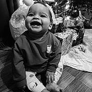 Colsen joined the competition — help win amazing prizes! baby, child, smile, happy, christmas_tree, presents, holiday, floor, indoors, sitting, clothing, sweater, pants, toes, hand, face, cute, festive, decorations, black_and_white