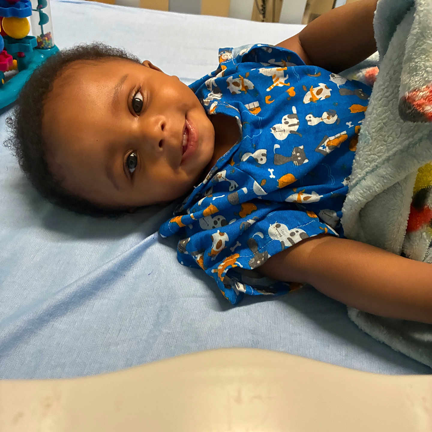 Javelle joined the competition — help win amazing prizes! baby, smiling, crib, blanket, blue_clothing, onesie, toy, nursery, infant, child, face, happy, lying_down, bed, furniture, patterned_clothing, arm, head, indoor, cozy