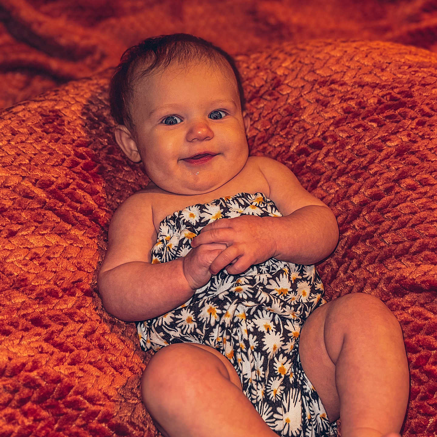 Jaylin is registered to the contest to win money with this photo: baby, blanket, child, clothing, cozy, cute, face, feet, hands, happy, indoors, infant, orange, patterned_clothes, portrait, sitting, skin, smile, texture, young
