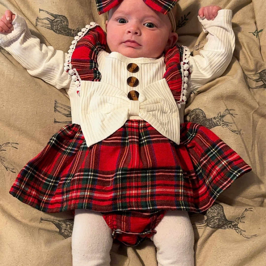 Elsie-Jean is registered to the contest to win money with this photo: baby, blanket, bonnet, cap, clothing, costume, couch, cushion, face, furniture, glove, hat, head, homedecor, hood, person, photography, portrait, skirt, tartan