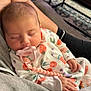 baby, sleeping, pacifier, onesie, cherry_pattern, hand, arm, indoor, carpet, furniture, person, cozy, cute, infant, child, relaxing, soft, clothing, rest, home