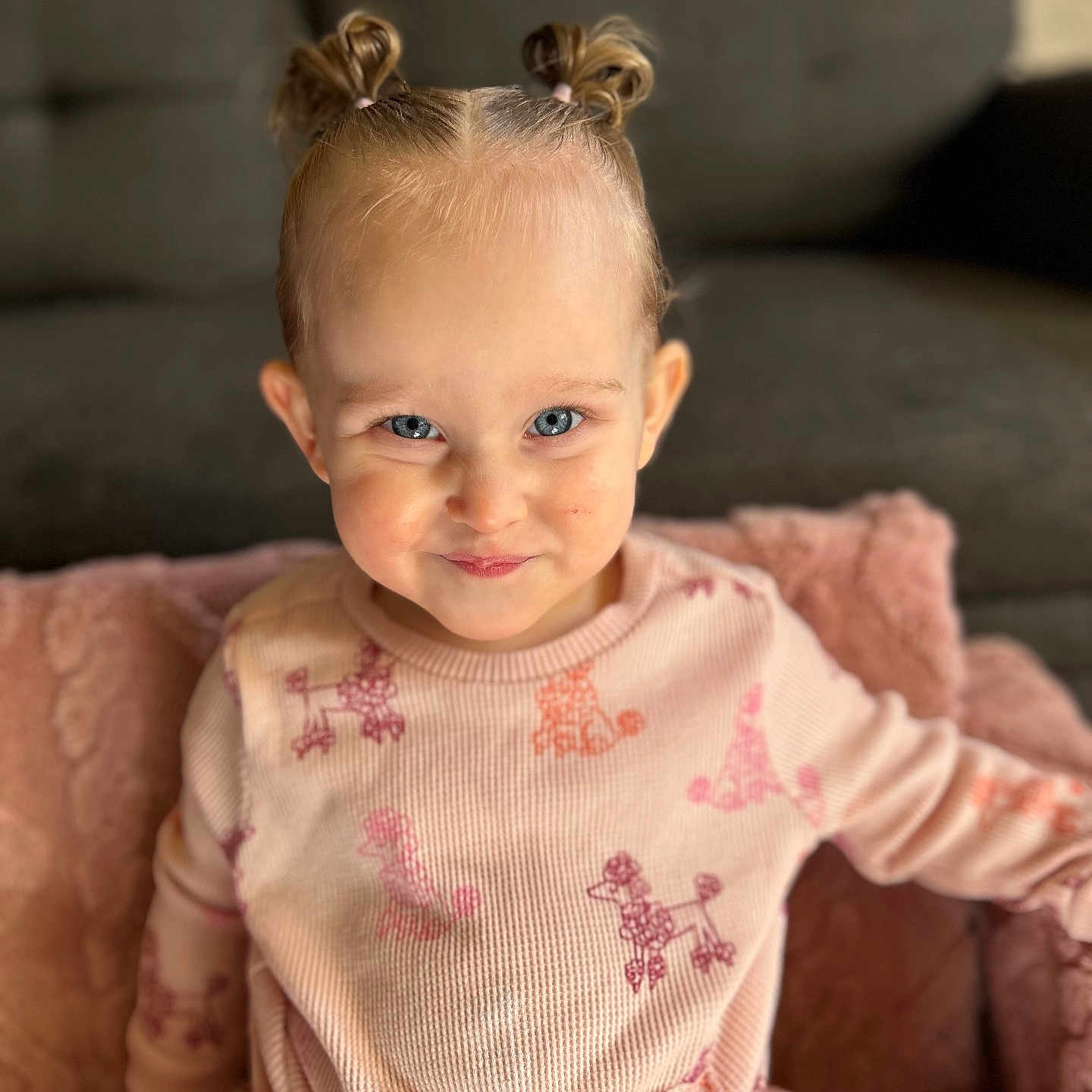 Sayla-Wren is registered to the contest to win money with this photo: blue_eyes, casual_wear, child, cozy, cushion, cute, hair_buns, happy, home, indoor, person, pink_clothing, playful, poodle_pattern, portrait, sitting, smile, soft_focus, toddler, young_child