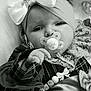 Sienna Mae is registered to the contest to win money with this photo: baby, pacifier, bow, headband, closeup, black_and_white, lace, beads, clothing, portrait, infant, cute, hand, face, child, patterned_clothing, soft_lighting, indoor, young_child, accessory