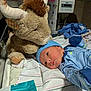 Devon joined the competition — help win amazing prizes! newborn, baby, hospital, bed, plush_toy, stuffed_animal, bull, blue_clothing, hat, blanket, infant, face, lying_down, medical_equipment, diaper_packaging, cute, soft_toy, child, baby_clothes, newborn_care