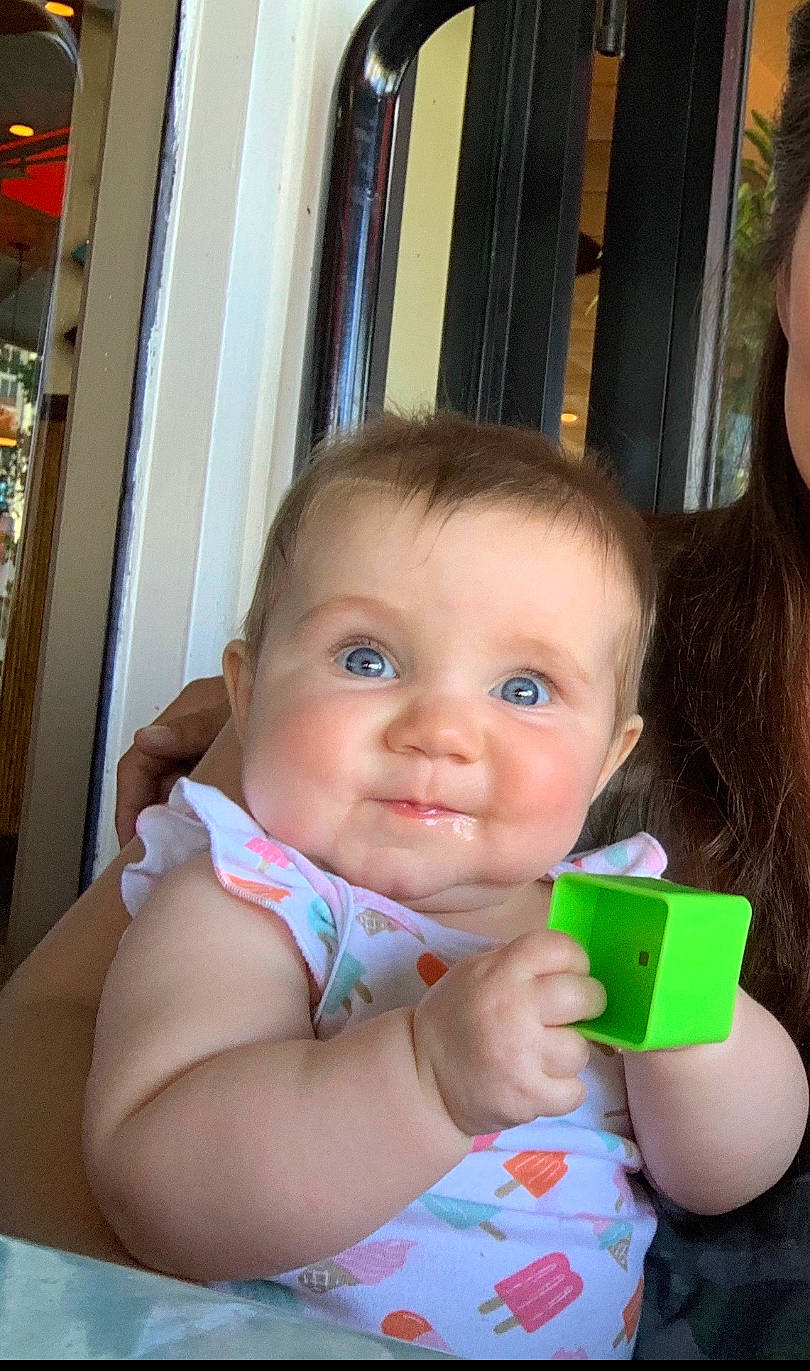 Isabella is registered to the contest to win money with this photo: arm, baby, cheek, child, eyelash, finger, fun, happy, head, iris, leisure, lip, nail, nose, person, sitting, skin, smile, thumb, toddler