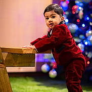 Ajvin joined the competition — help win amazing prizes! toddler, child, red_suit, wooden_bench, christmas_tree, holiday, indoor, green_grass, decorations, ornaments, curious, standing, footwear, nike_shoes, portrait, festive, young_child, cute, celebration, background_blur