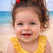 Zélie participe au concours pour gagner de l'argent avec cette photo : baby, child, smiling, beach, ocean, yellow_dress, headband, pom_poms, curly_hair, happy, portrait, outdoor, sunny, cute, infant, ruffled_clothing, skin, face, blue_sky, sand