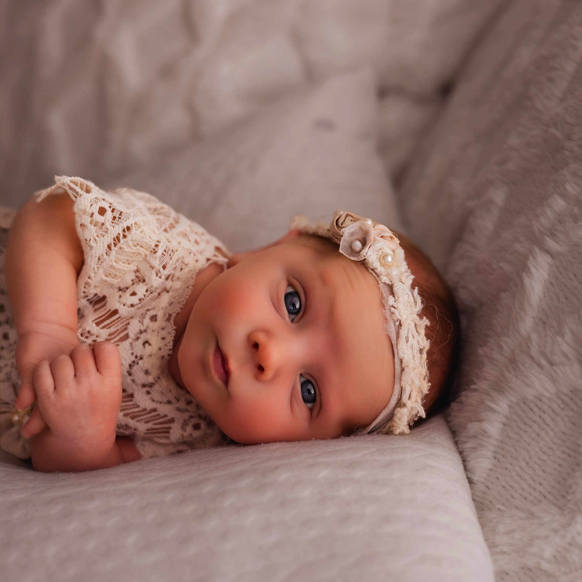 Emma is registered to the contest to win money with this photo: adorable, baby, baby_girl, blue_eyes, child, closeup, cute, face, hand, headband, indoors, infant, lace, lying_down, newborn, peaceful, person, portrait, skin, soft_blanket